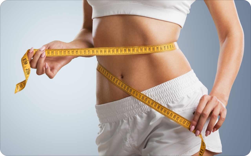 A woman measuring her waist with a tape measure